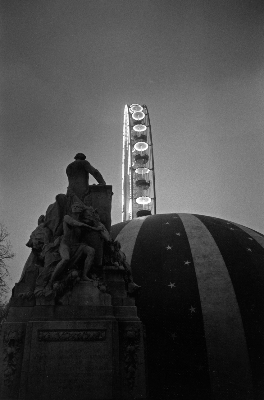 Paris - &eacute;t&eacute; 1987 &ndash; La Grande Roue, jardin des Tuileries.
Traditionnellement avec le mois d'ao&ucirc;t vient le temps des f&ecirc;tes foraines. C'est le cas chez moi, ici, dans le sud, ou la f&ecirc;te populaire un peu d&eacute;su&egrave;te remplace les festivals culturels de juillet. Ce soir, les man&egrave;ges s'&eacute;brouent sur la grande place, en bas du rocher... C'&eacute;tait la m&ecirc;me chose &agrave; Paris, au Jardin des Tuileries, qui &eacute;tait envahi par les forains au beau milieu de l'&eacute;t&eacute;. Peut-&ecirc;tre est-ce encore ainsi aujourd'hui... Cette image, elle a fait l'affiche de l'une de mes toutes premi&egrave;res expositions parisiennes, &laquo;&nbsp;Jours de F&ecirc;te&nbsp;&raquo;. J'ai du mal aujourd'hui &agrave; retrouver cette na&iuml;vet&eacute; qui me permettait de capter ces instants un peu magiques, un peu tristes parfois, un peu ridicules aussi, instants typiques des f&ecirc;tes d'avant...