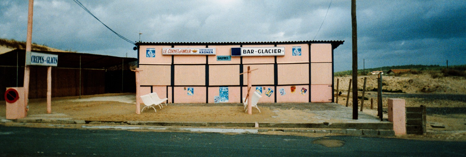 Le Cornet d'Amour - Moliets Plage - France, novembre 1991
C'est l'&eacute;t&eacute;, les plages se peuplent, le soleil tape, les corps se d&eacute;nudent... Il doit en &ecirc;tre de m&ecirc;me &agrave; Moliets Plage, sur la c&ocirc;te aquitaine, ou l'oc&eacute;an frappe la dune qui s'&eacute;tend &agrave; perte de vue. J'aime bien Moliets, les Landes, sa sent le pin &agrave; plein nez. Sur la plage serpente le Courant d'Huchet, fantasque petite rivi&egrave;re qui se vide dans l'Atlantique, et dont le cours varie chaque jour en fonction de l'&eacute;tat de la dune. En haut de celle-ci, dans le temps, il y avait le &laquo;&nbsp;Cornet d'Amour&nbsp;&raquo;, baraque &agrave; glaces et chichis, qui bravait les canons de l'esth&eacute;tique par toute saison, m&ecirc;me en hiver, comme ici. Je crois que la baraque a fini par &ecirc;tre ras&eacute;e, elle ne correspondait plus aux nouveaux crit&egrave;res de standing du lieu...
