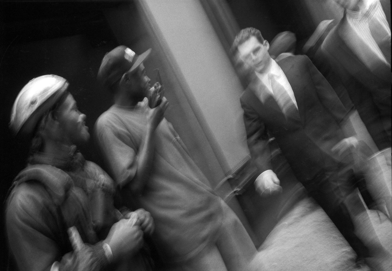 Les hommes en noir &ndash; Wall Street, New York &ndash; Avril 1997
La particularit&eacute; de cette image, ce n'est pas son sujet, m&ecirc;me si les deux &laquo;&nbsp;traders&nbsp;&raquo; de Wall Street c&ocirc;toyant les ouvriers noirs ont quelque chose de symbolique. Ce n'est pas non plus le joli flou de fil&eacute; que j'avais impos&eacute; &agrave; mon Leica, photo prise &agrave; la va-vite, certainement sans r&eacute;ellement viser. Non, l'histoire de cette image, c'est qu'elle restera &agrave; tout jamais fig&eacute;e dans un unique tirage r&eacute;alis&eacute; au fond de mon laboratoire, car le n&eacute;gatif a &eacute;t&eacute; perdu par le labo qui devait en r&eacute;aliser une s&eacute;rie. J'avoue que j'&eacute;tais assez furieux &agrave; l'&eacute;poque d'avoir ainsi irr&eacute;m&eacute;diablement perdu quelques dizaines d'images r&eacute;alis&eacute;es dans la Grosse Pomme. Cette m&eacute;saventure ne m'est arriv&eacute;e qu'une fois dans ma vie de photographe, heureusement. Par contre, je n'ai jamais compt&eacute; le nombre de photos manqu&eacute;es &agrave; cause d'un appareil que j'avais oubli&eacute; de charger en pellicule &hellip;