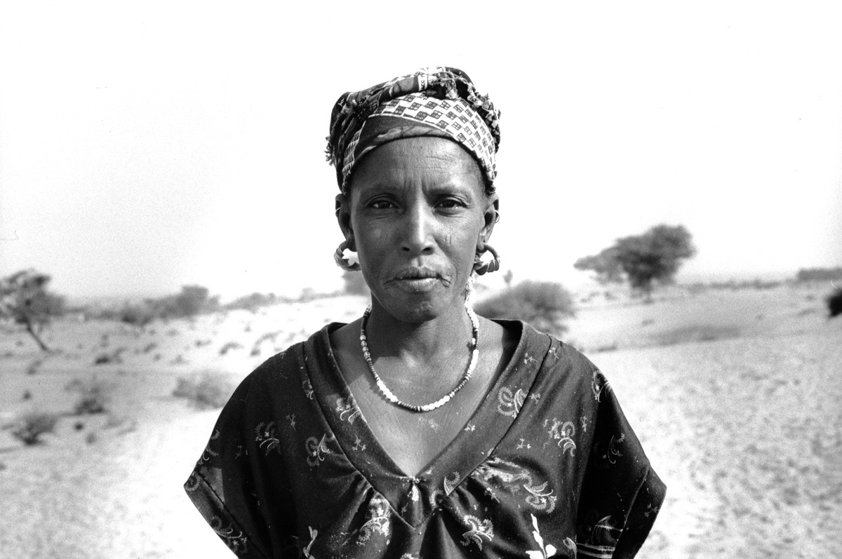 Gorom Gorom - Burkina Faso - Octobre 1998. Avec Alphonse, notre chauffeur, nous décidons de nous enfoncer un peu dans le désert, quelques dizaines de kilomètres au nord de Gorom. Ici, les frontières s'effacent, on ne sait plus si on est au Faso ou au Mali, qu'importe, on est dans le Sahel. Au détour d'une dune, surgis de nulle part, nous voici nez à nez avec un groupe de Peuls. Essentiellement des femmes et des enfants, peut-être en route pour le grand marché. Lors de ce voyage, j'avais emporté avec moi un polaroïd, pour offrir des images à ceux qui voulaient bien poser pour moi. Une séance de portraits s'improvise alors, chacun posant dans ce décor immense. Et à tous, je donnais un portrait instantané. Succès garanti, il y avait la queue pour se faire immortaliser. Quant aux gamins, ils se disputaient les cartouches vides de pellicule, comme s'il s'agissait du plus précieux des trésors.