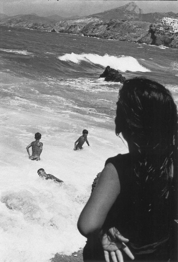 Grotta, Naxos, Gr&egrave;ce &ndash; mai 1999. &laquo;&nbsp;La vague&nbsp;&raquo;&nbsp;: cette jeune fille regardant ses copains d&eacute;fier les d&eacute;ferlantes par un jour de grand vent pr&egrave;s du port de Naxos m'a valu le Prix Ilford en l'an 2000 &hellip; et un peu plus tard les commentaires &eacute;logieux d'un certain Bernard Plossu qui a d&ucirc; voir souffler dans cette sc&egrave;ne l'esprit de ses propres images... Alors que je prenais ce clich&eacute;, j'&eacute;tais loin de penser que cet instant photographique allait avoir un tant soit peu de succ&egrave;s. Avec le recul, ce qui me plait le plus, c'est la posture &ocirc; combien f&eacute;minine et nonchalante de la fille...
